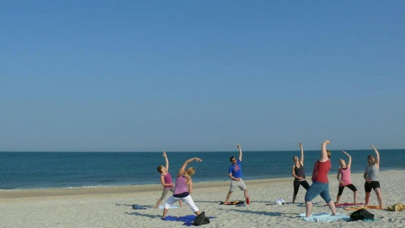 Séance de yoga sur la plage de l'île de Sylt