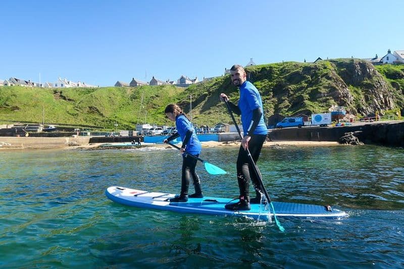 Leçon de stand up paddle dans le port historique de Portknockie